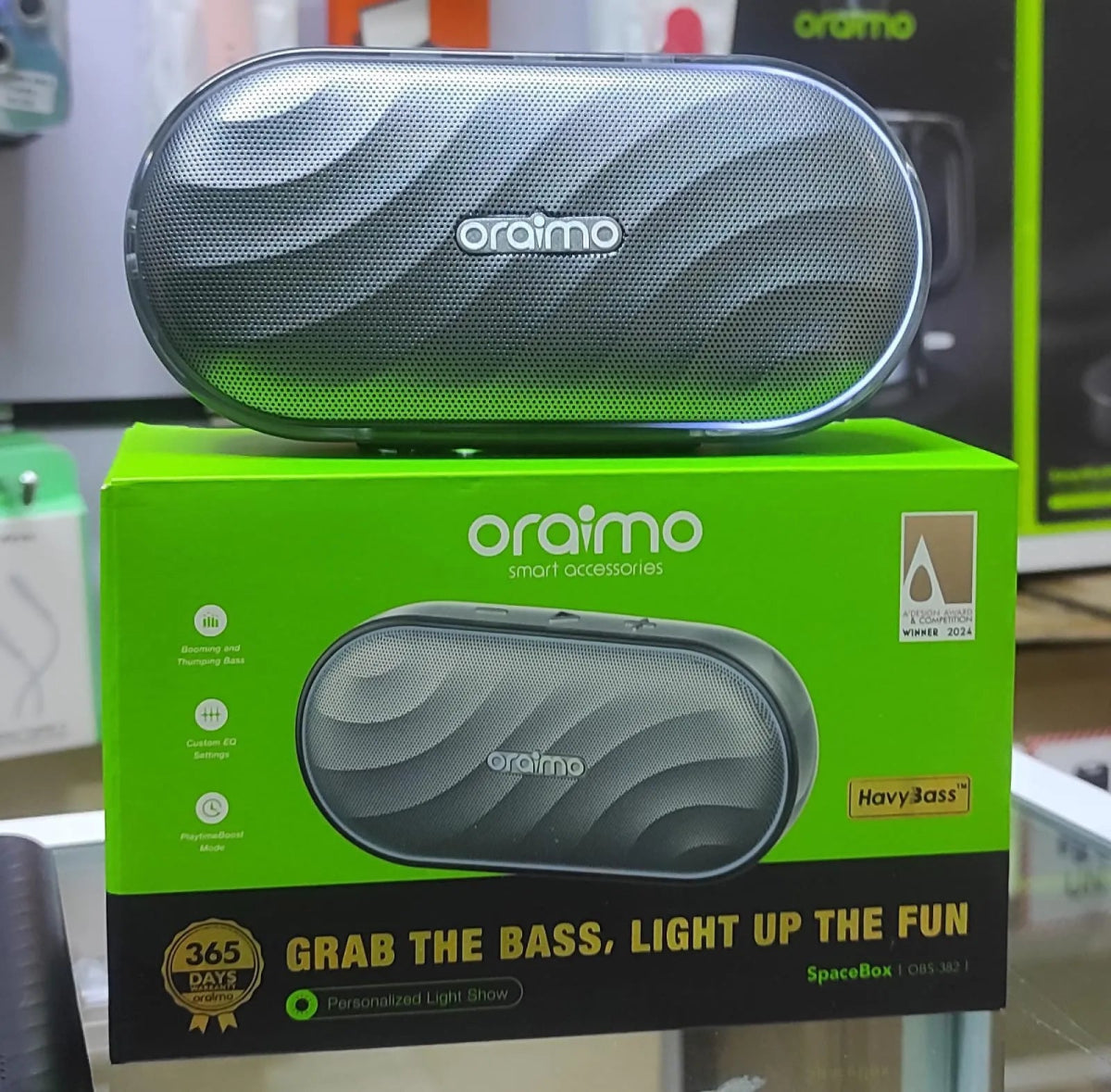Oraimo SpaceBox 8W FM Wireless Speaker Upto 16 Hours Playtime - Neo Tech Accessoriesoraimo SpaceBox speaker on top of its packaging box with branding and product details.