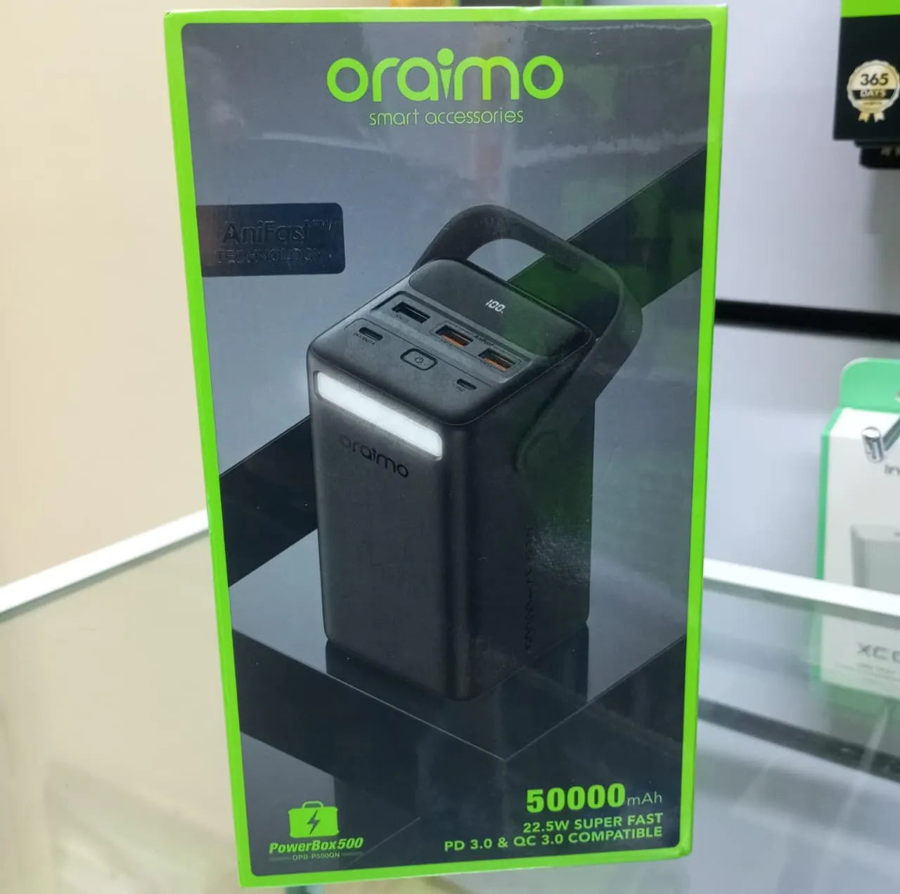 Oraimo power bank packaging with green border on a reflective surface