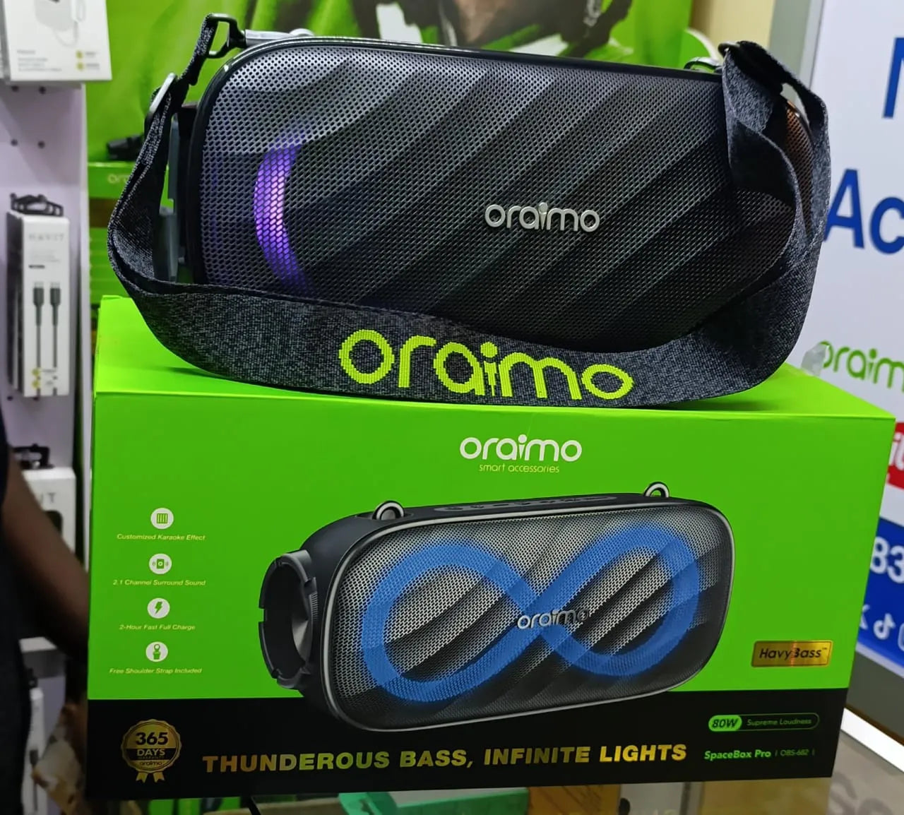 oraimo SpaceBox Pro portable speaker with its packaging on a green box